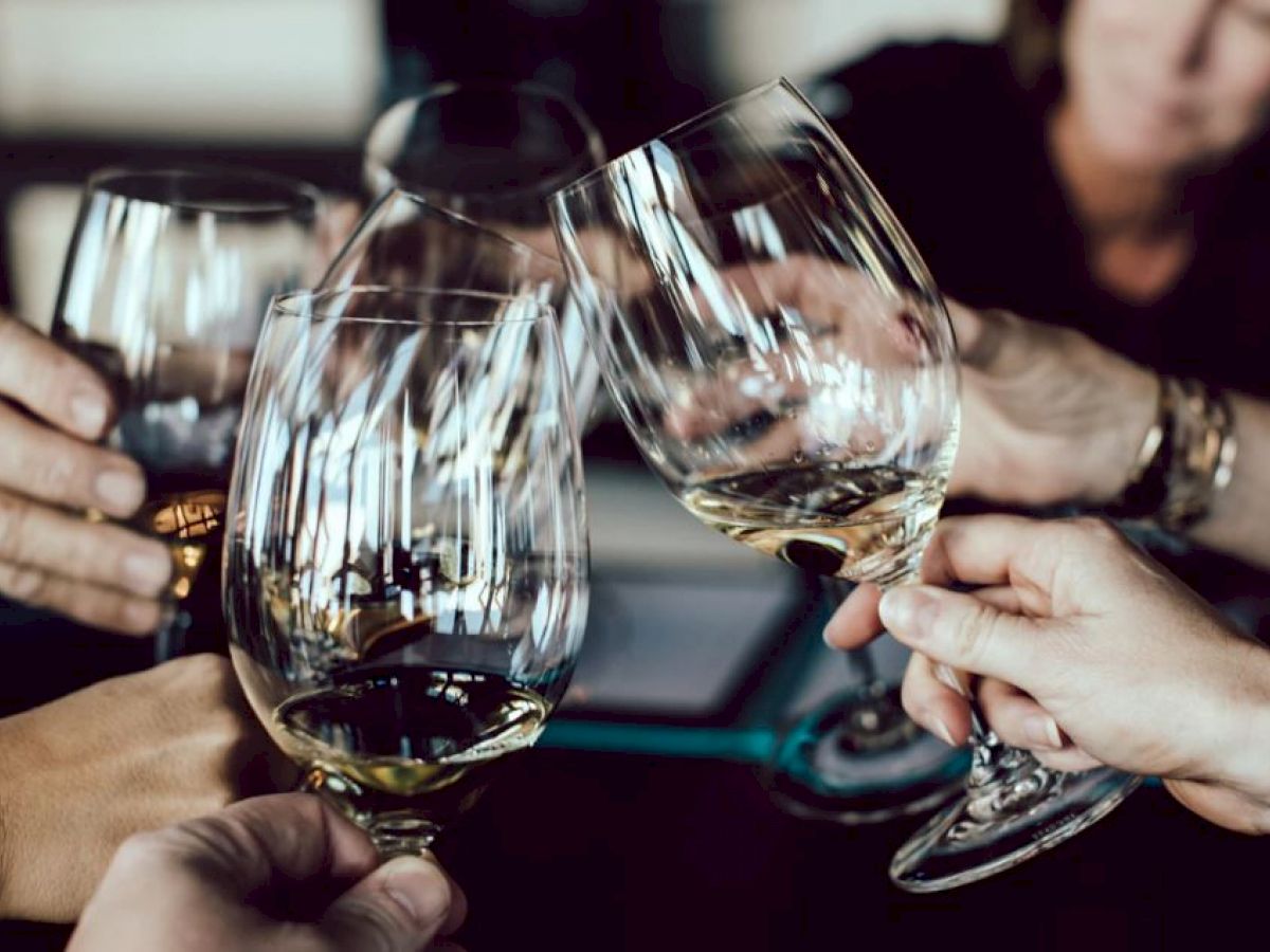 Five people are clinking their wine glasses in a celebratory toast, creating a festive atmosphere.