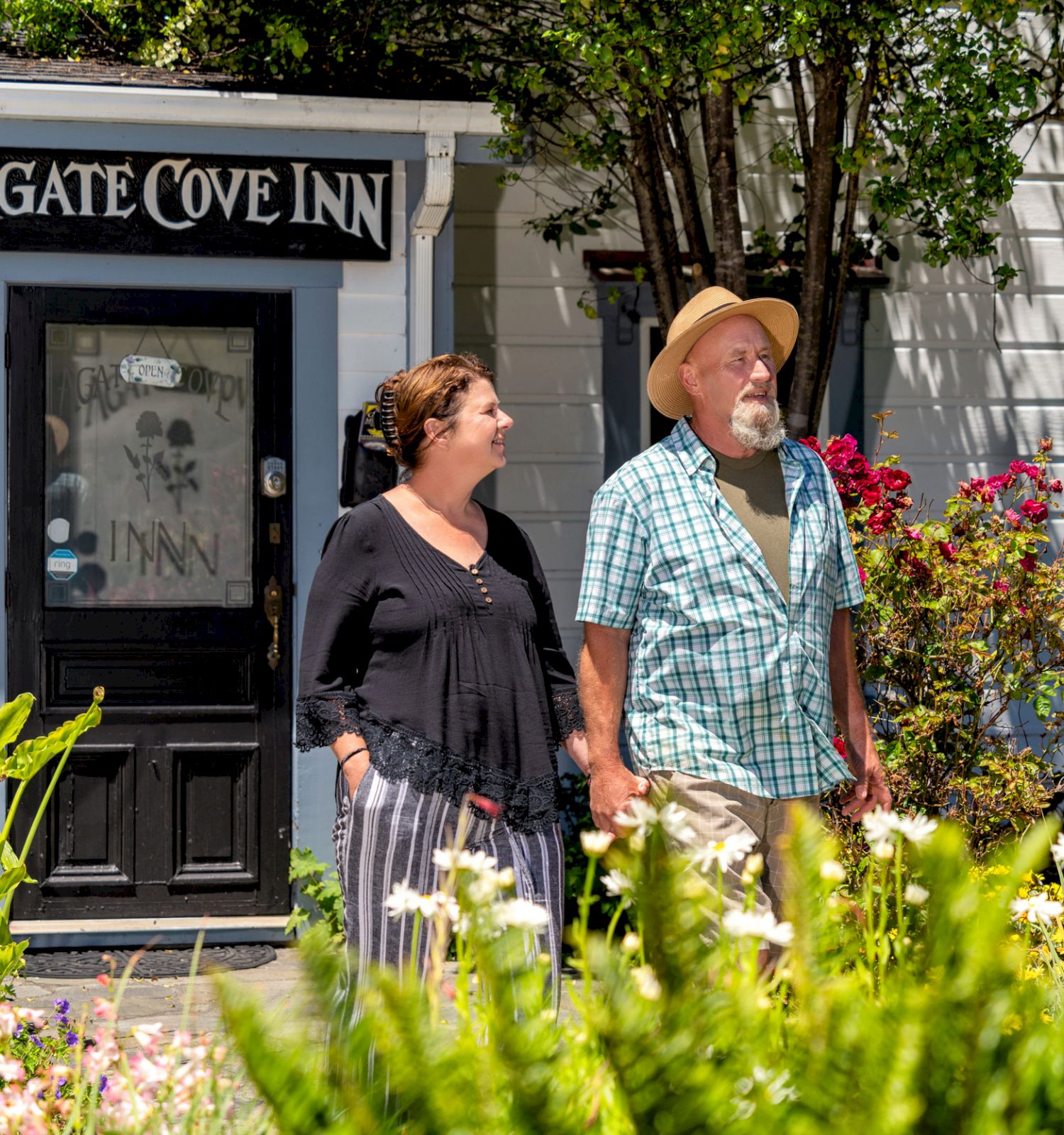 A man and woman are standing outside a building with a sign that reads 